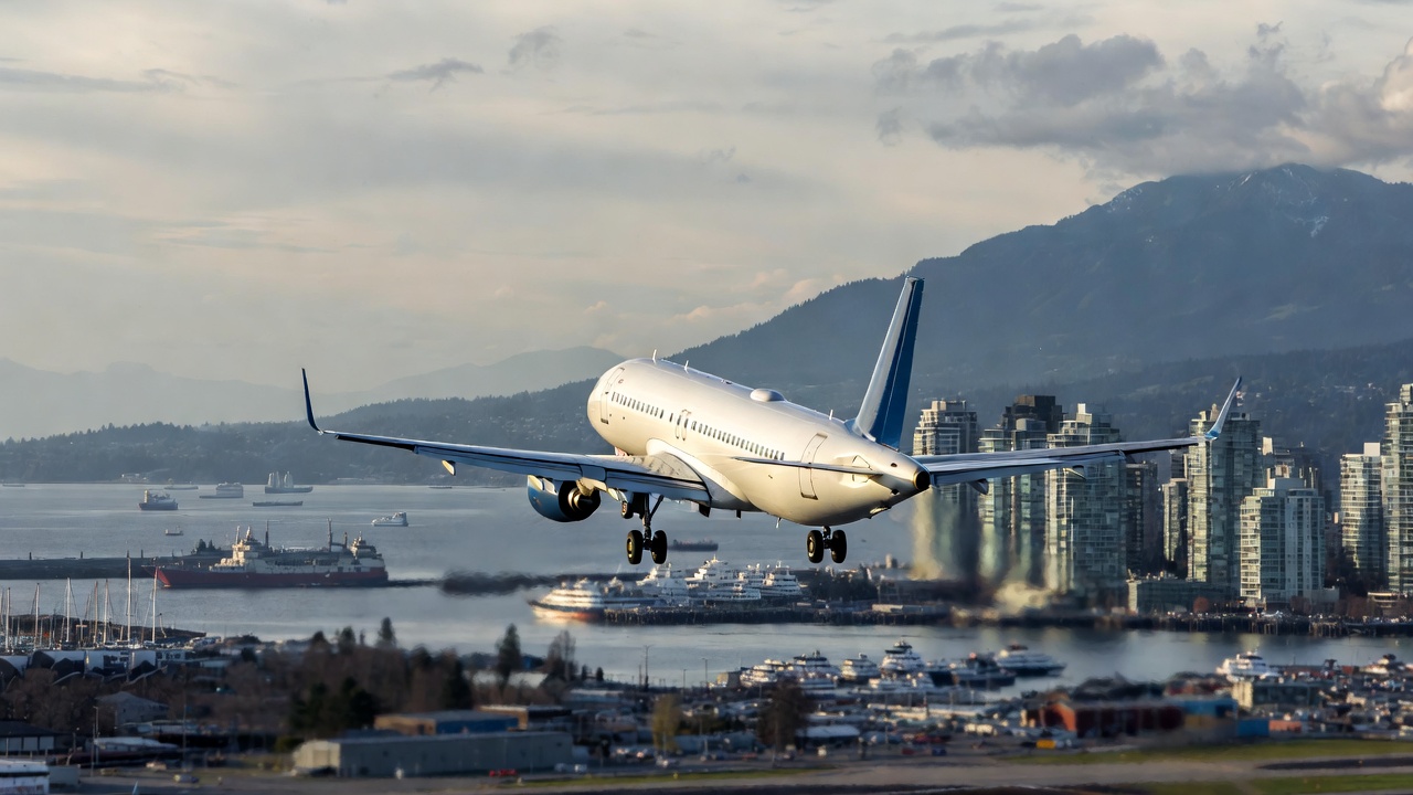 Plane landing in Vancouver with city skyline